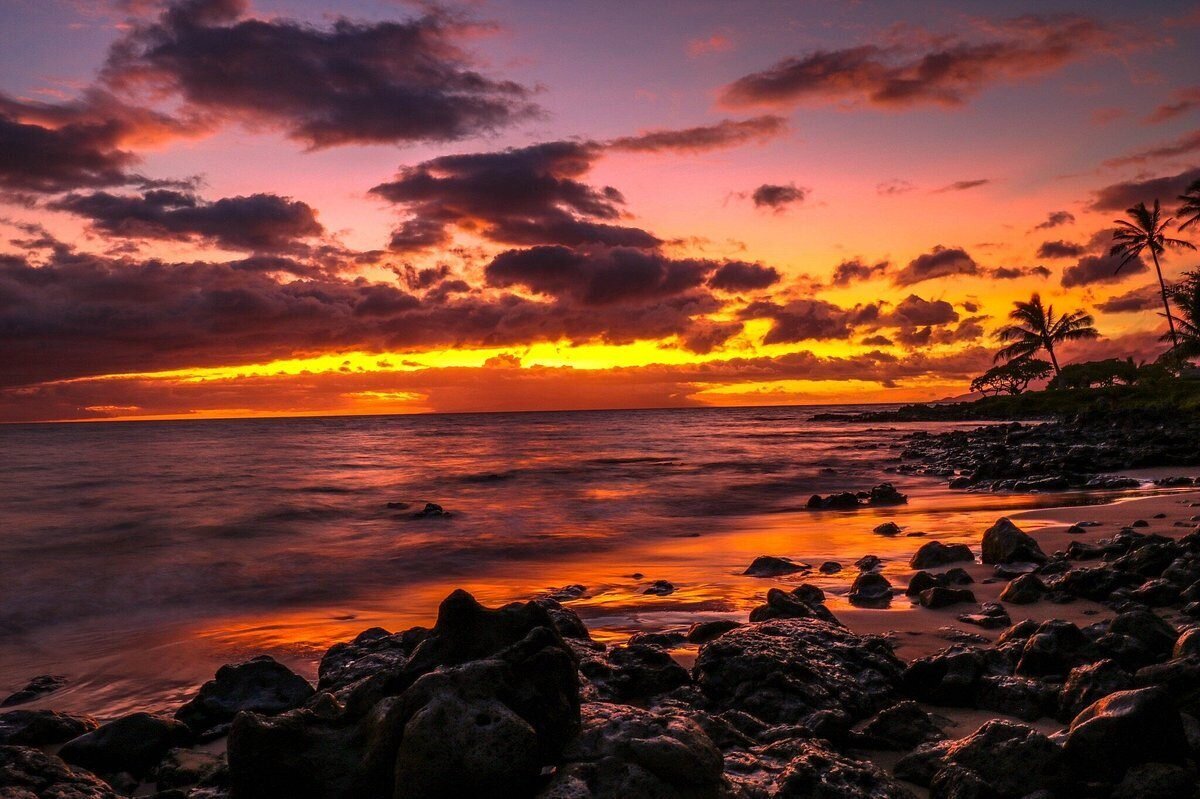 wailea-beach-maui-photographer Vibrant pink and orange sunset over the rocky shoreline at Wailea Beach in Maui, a romantic location for engagement photos