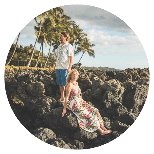 julie-maui-photography-client-dreamgraphy.jpg A couple on a lava rock coastline framed by palm trees