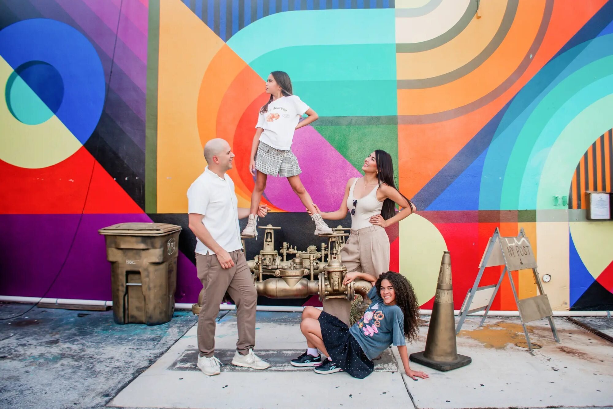 Miami Photographer | Family Session at Wynwood Walls A family of four posing and laughing in front of a colorful mural at Wynwood Walls, Miami — captured by a Dreamgraphy Miami photographer