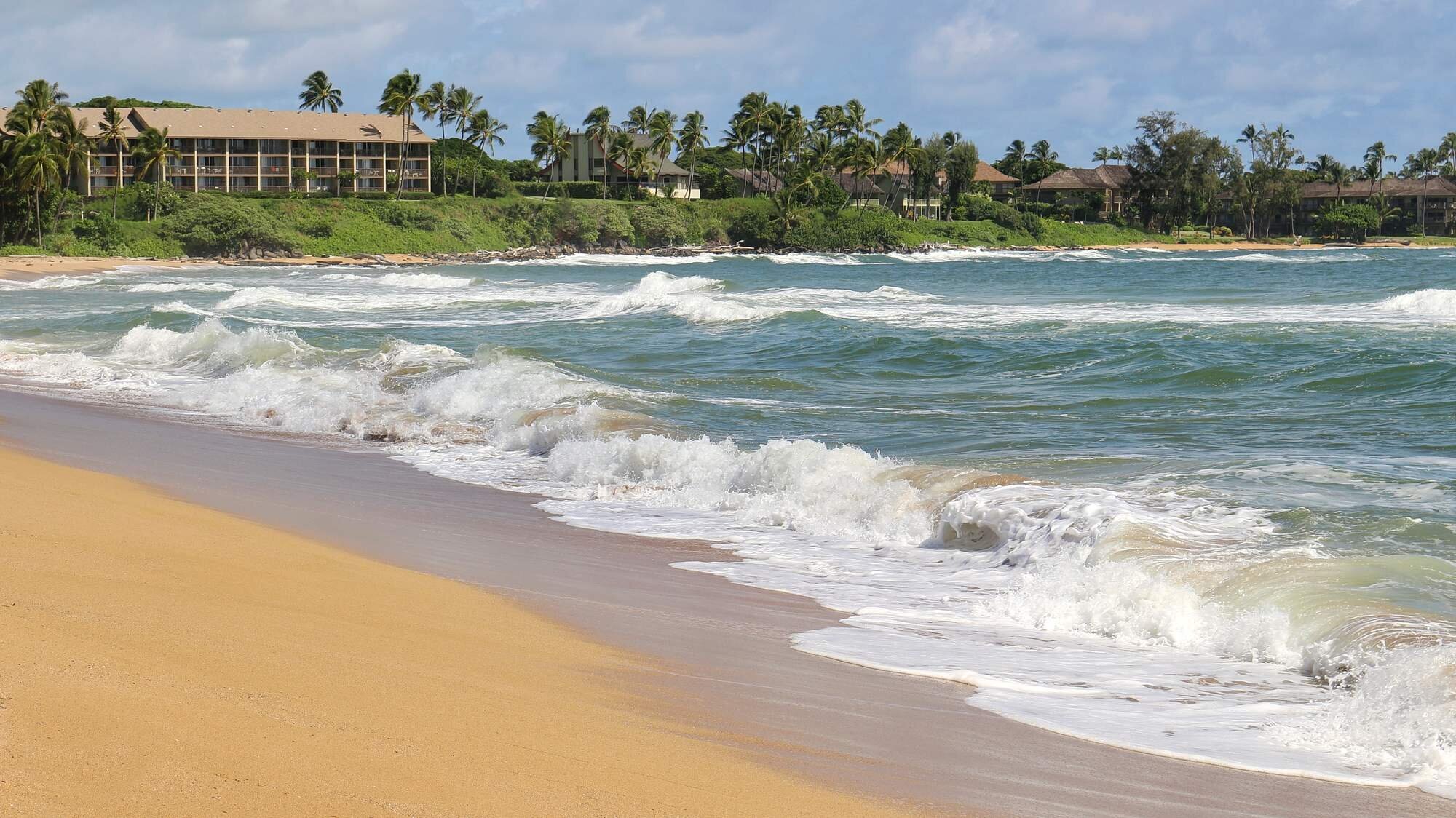 Wailua Beach on Kauai's East Side near Kapa'a, with palm trees, turquoise water, and golden sand