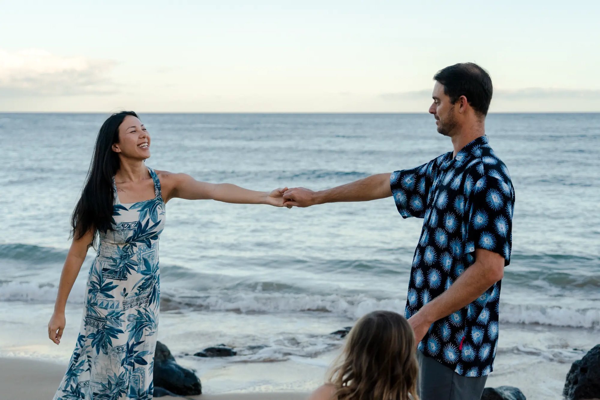 Parents dancing on beach at sunset