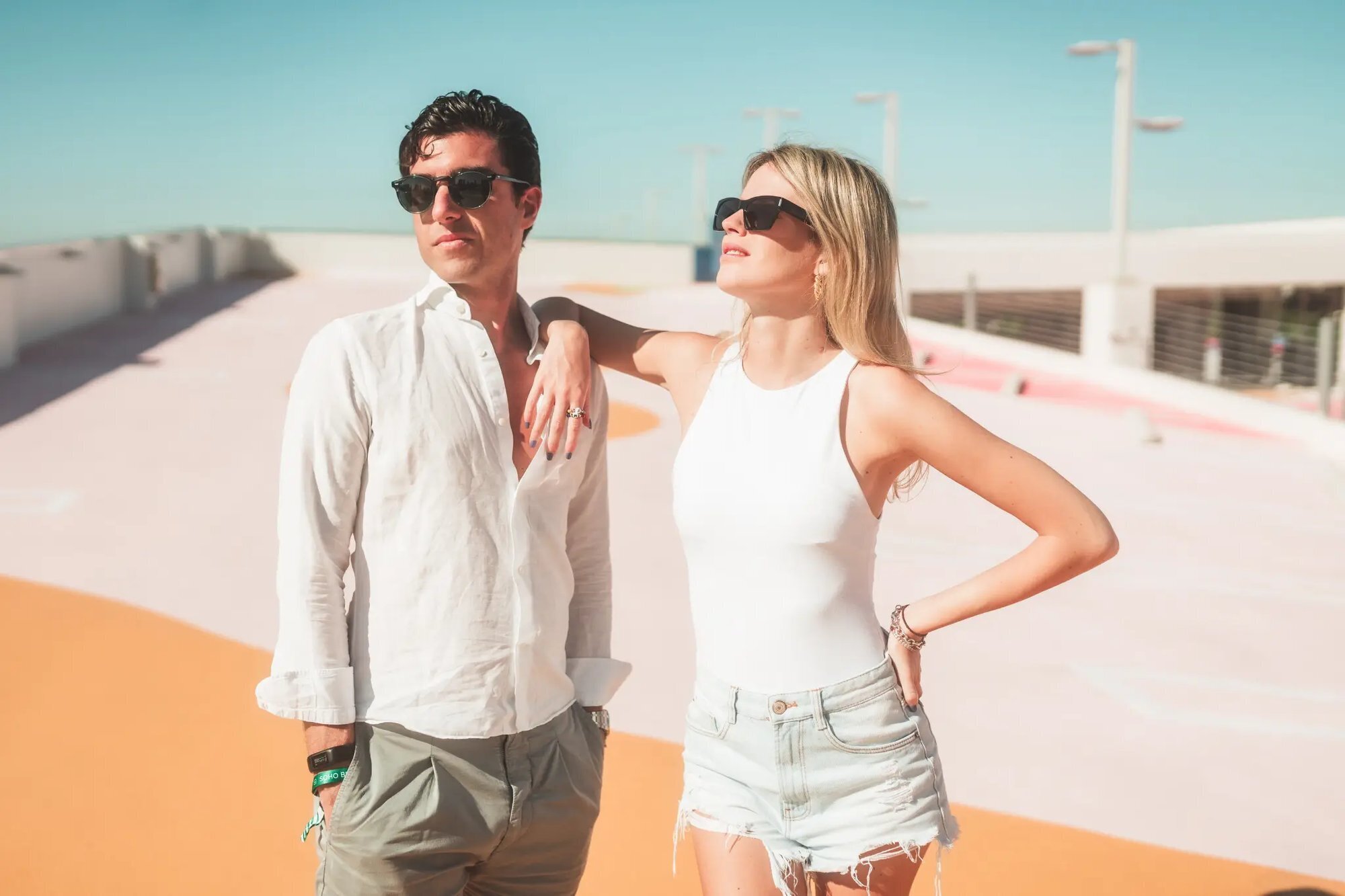 A stylish couple standing together on a sun-drenched rooftop in Miami Florida during a vacation couple photoshoot
