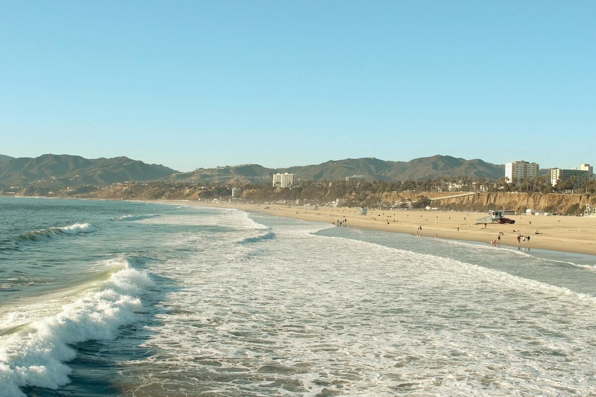 Wide sandy beach with mountains in the background at Will Rogers State Beach, a popular Los Angeles family photography location