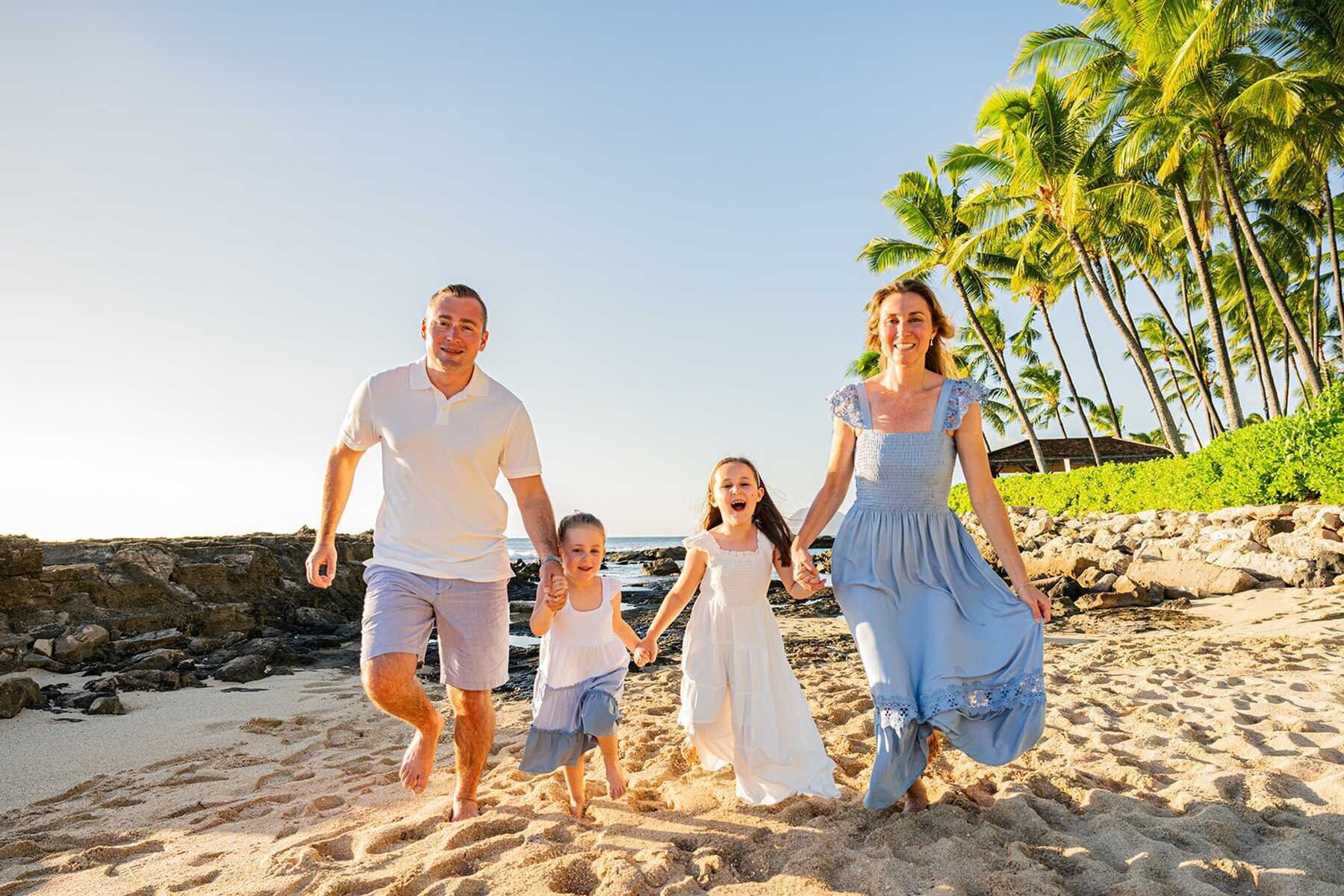 Family laughing together on a beach during a professional vacation photoshoot
