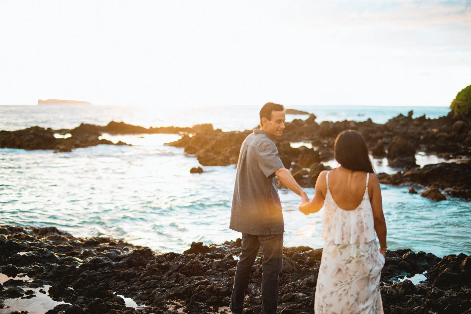 A couple posing on a dramatic lava rock coastline in Maui Hawaii during a romantic couple photoshoot