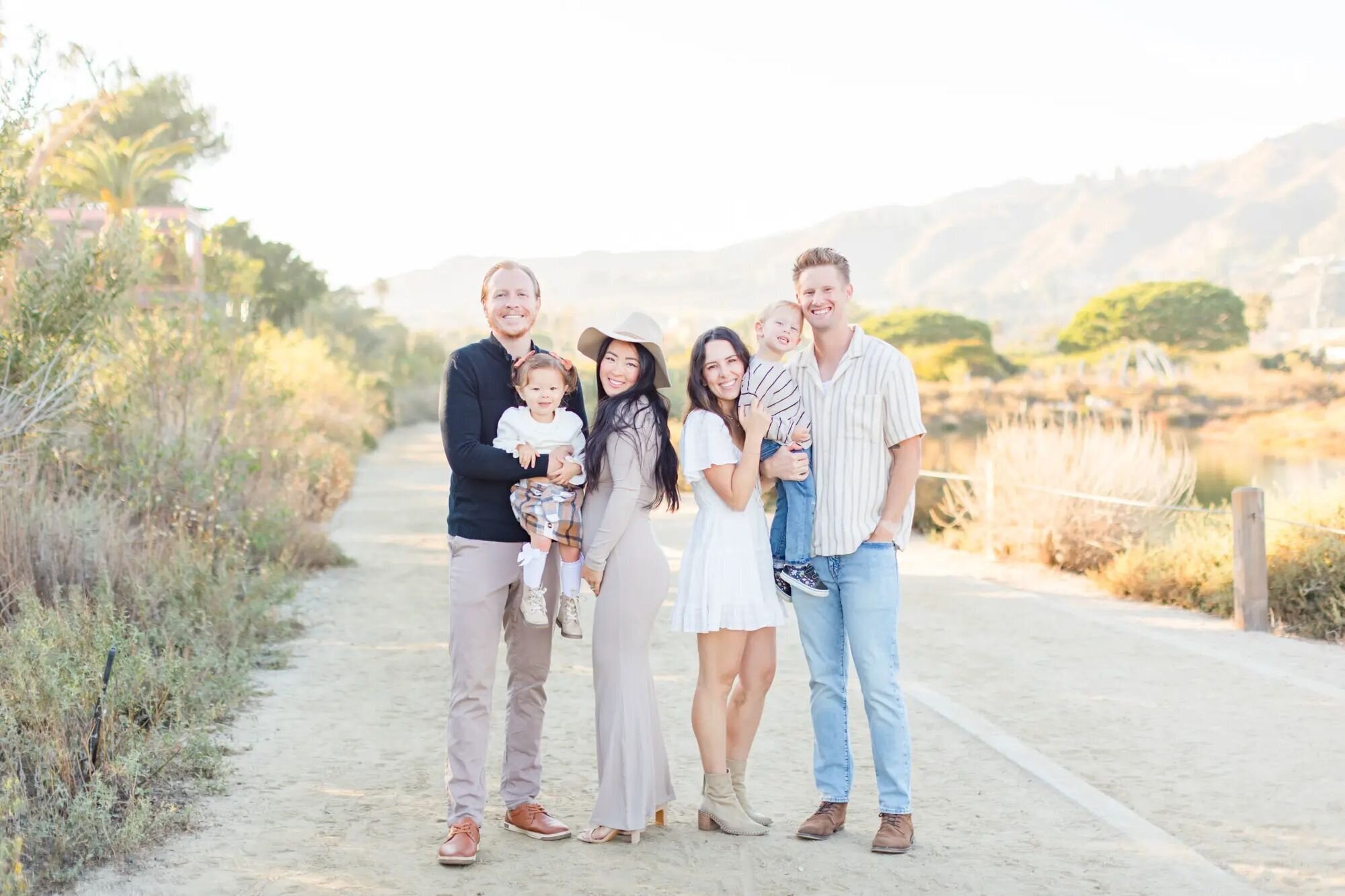 Two families with young children smiling together outdoors — Dreamgraphy vacation photography packages