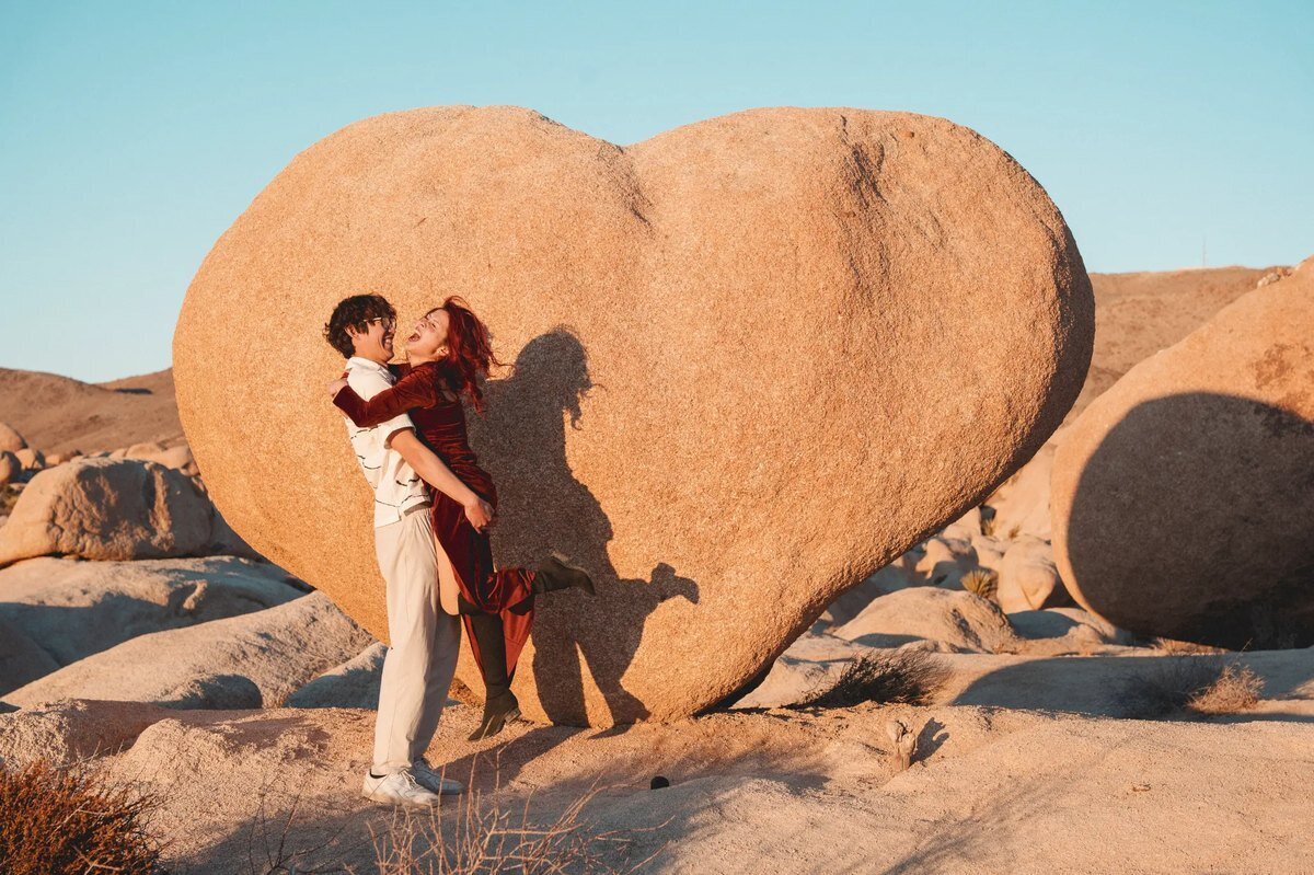 Los Angeles Photographer — Couples Session at Joshua Tree National Park Los Angeles photographer capturing a couple laughing and spinning together in front of the iconic heart-shaped boulder at Joshua Tree National Park at golden hour