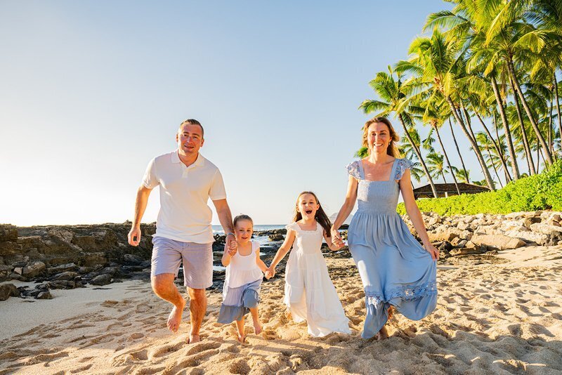 Family laughing together on a beach during a professional vacation photoshoot