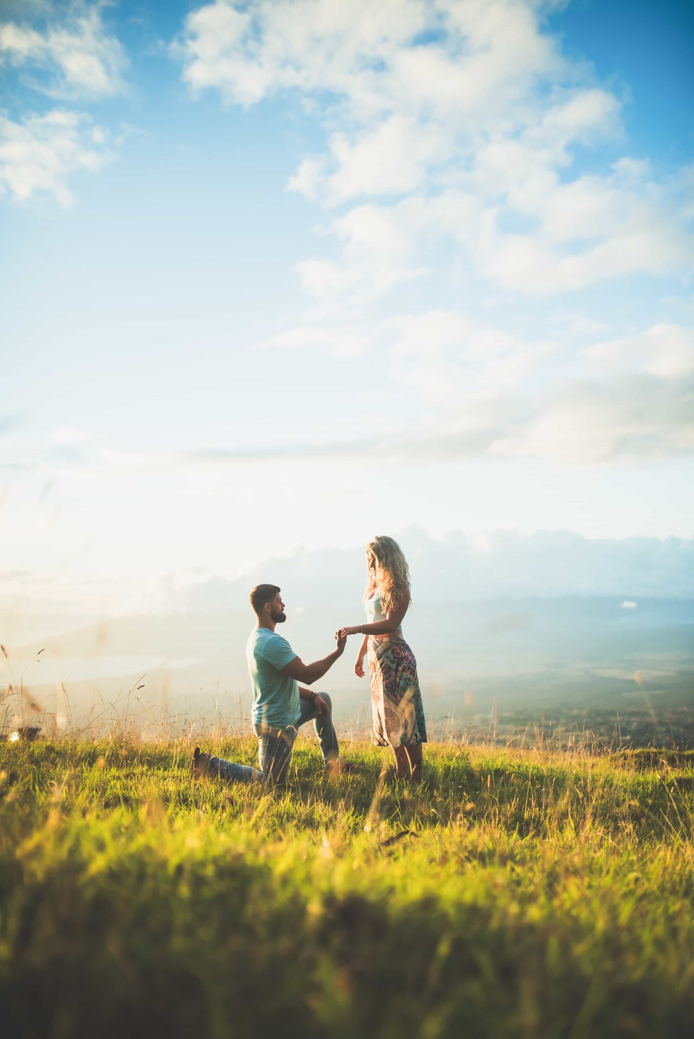 maui-proposal-photographer-dreamgraphy-upcountry-hillside Couple getting engaged in a hill with green grass during sunset time.
