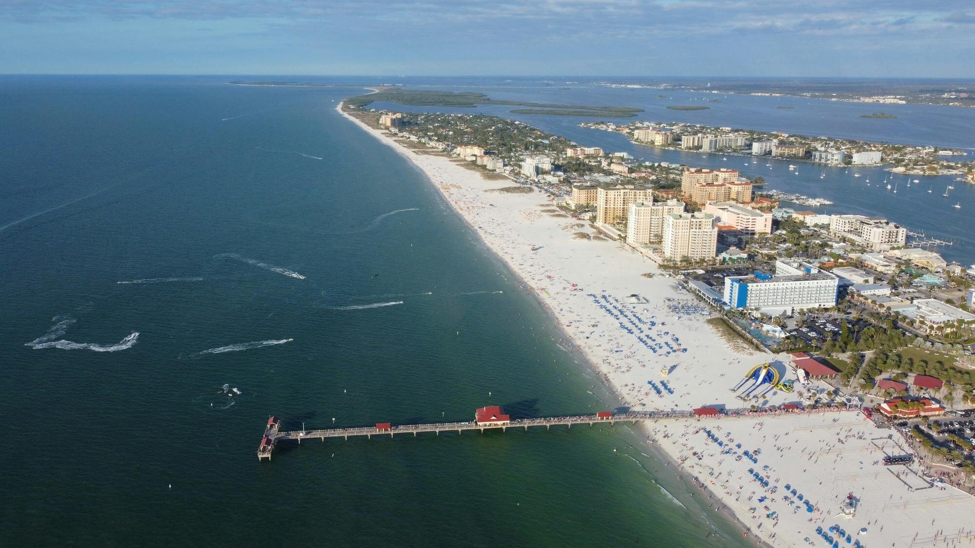 Aerial view of Clearwater Beach, Florida, showing the wide white sandy shoreline, turquoise Gulf waters, and beachfront hotels — a popular Tampa photo session location by Dreamgraphy