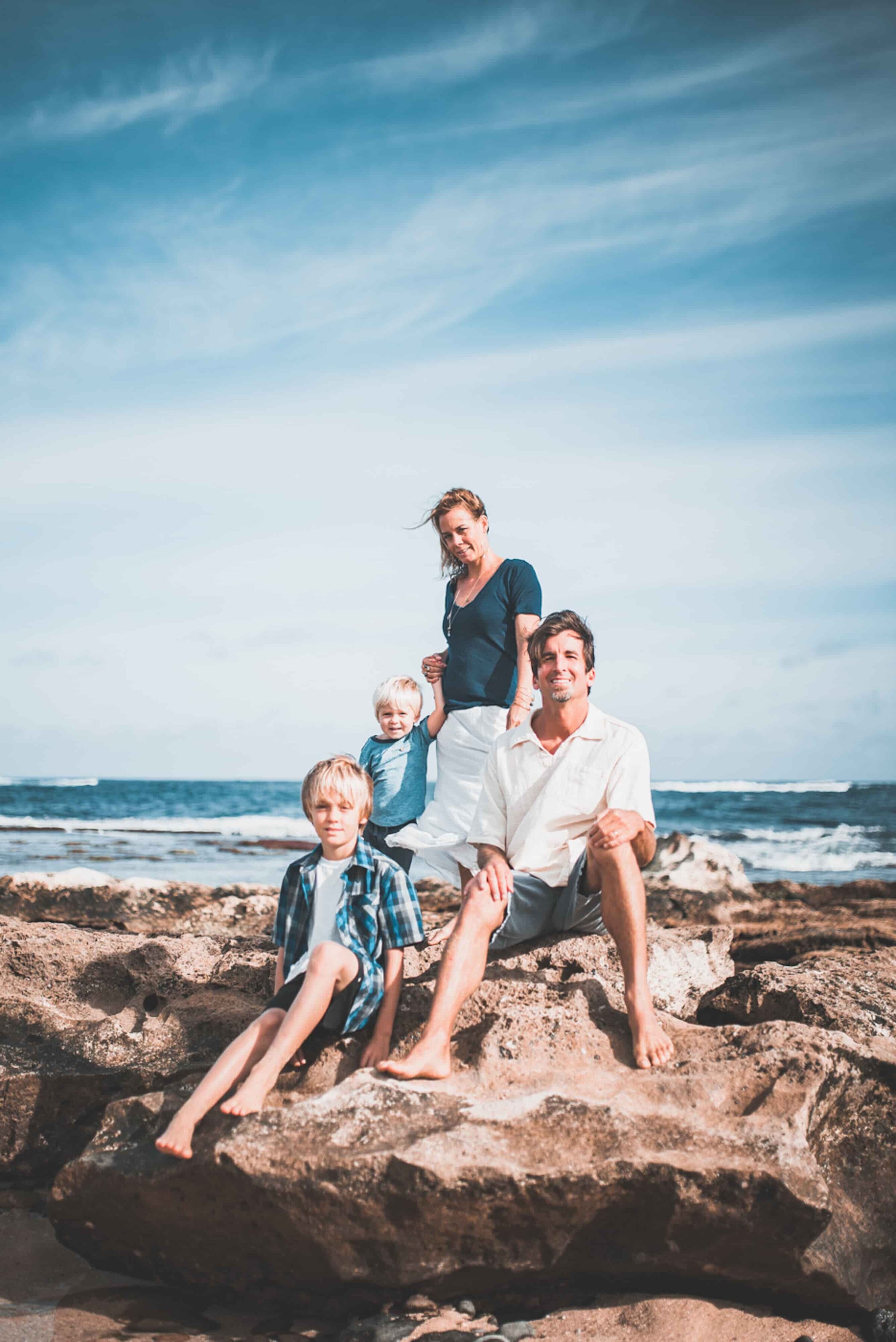 Family of four with two boys on coastal lava rocks