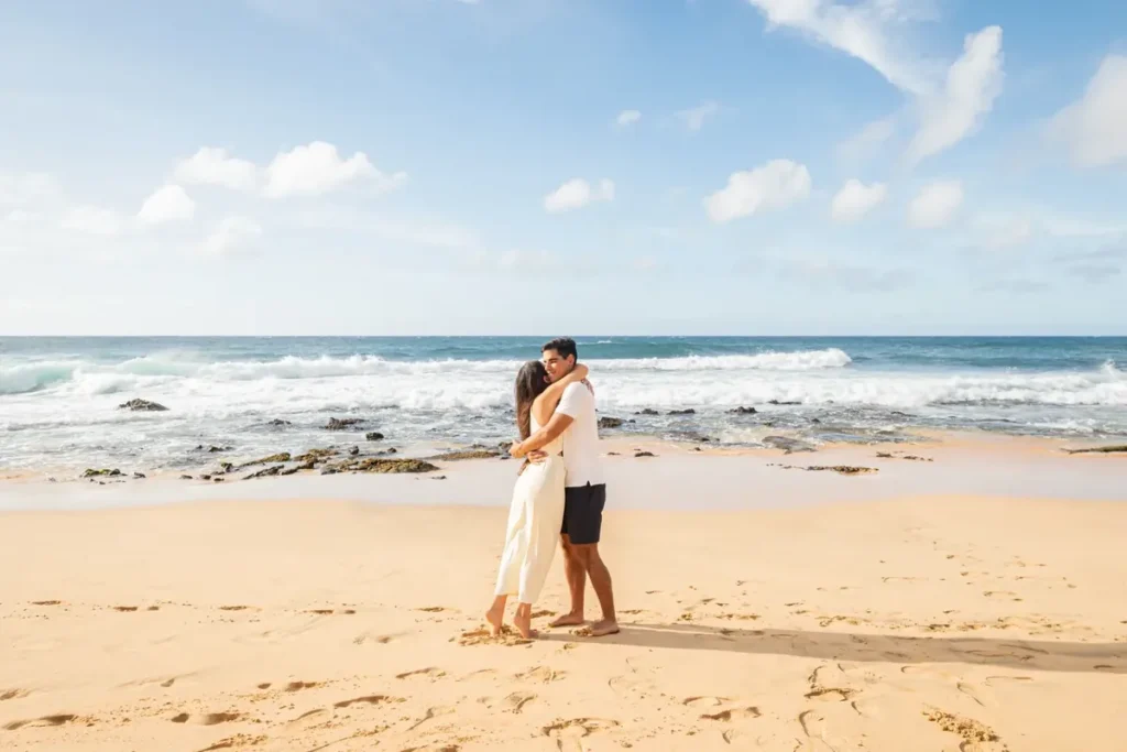 Couple embracing after a beach proposal at Mākena Cove Maui, framed by lava rock and blue ocean